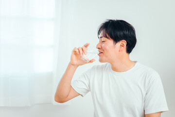 水・白湯を飲む男性（笑顔）
