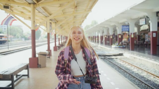 Asian girl taking photos for her close friends during going out on a trip at railway station posting pictures on online young lgbt lesbian, freedom lifestyle.