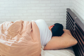ベッドで寝る男性（顔なし）
