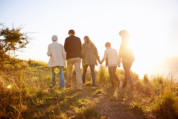Strolling on a golden afternoon. Rearview shot of a multi-generational family walking together at...