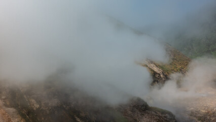 The geyser is located on the hillside. Thick hot steam rises above his boiler, hiding everything around. Poor visibility. Kamchatka. Valley of geysers.