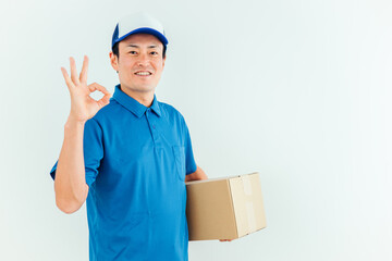 段ボールを持った作業着の男性
