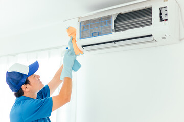 エアコン・空調設備の清掃をする作業着の男性（洗剤）
