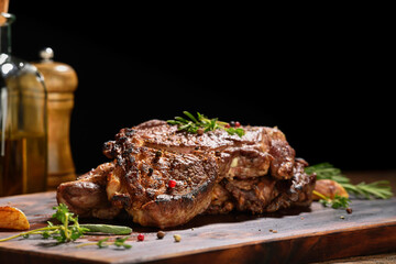 Cooked juicy steak meat beef with seasoning on wooden chopping board.