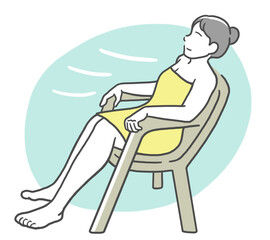 タオルを巻いて椅子に座り、外気浴を楽しむ若い女性