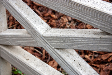 Close-up element of a decorative picket fence. Garden fence, side view.