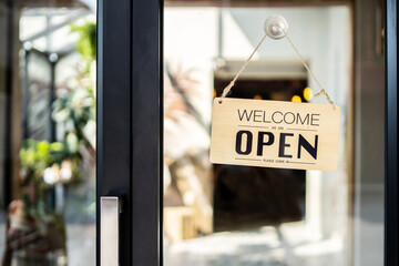 A business sign that says ‘Open’ on cafe or restaurant hang on door at entrance. Business...