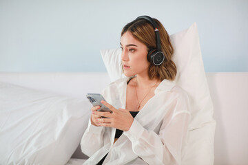 Happy woman listening to music on the bed at home , beautiful lifestyle on bed with l with gadget at home
