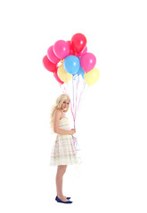 
Full length portrait of blonde girl wearing party dress, holding bunch of colourful balloons. Isolated on white studio background