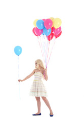 
Full length portrait of blonde girl wearing party dress, holding bunch of colourful balloons. Isolated on white studio background