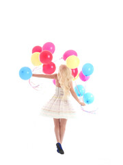 
Full length portrait of blonde girl wearing party dress, holding bunch of colourful balloons. Isolated on white studio background