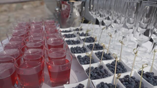 buffet in nature but round table with white tablecloth. Berries, juice and champagne glasses