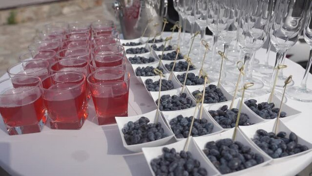 buffet in nature but round table with white tablecloth. Berries, juice and champagne glasses