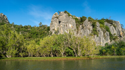 Fototapeta na wymiar along with river side of mangrove forest with green moutain and clear blue sky