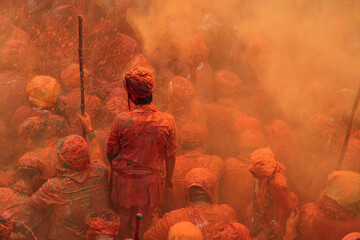 People throw colours to each other during the Holi celebration in Nandgaon, Uttar Pradesh, India. Holi is the most celebrated festival in India. - obrazy, fototapety, plakaty