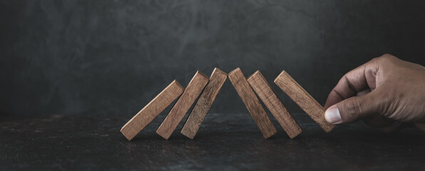 Hand place wooden block tower stack crash prevent or fall domino. concept of prevention of...