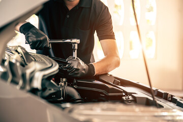 Close-up hand auto mechanic using the wrench to repairing car engine problem. Concepts of check and inspection car care maintenance and servicing.