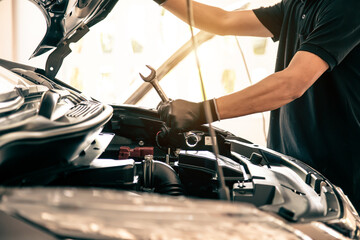 Close-up hand auto mechanic using the wrench to repairing car engine problem. Concepts of check and inspection car care maintenance and servicing.