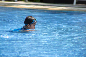 cute asian little boy swimming