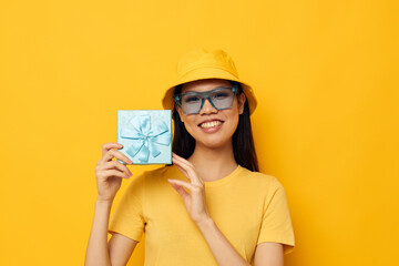 pretty asian woman gift box posing sunglasses and hat