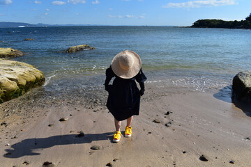 海藻が多い海に散歩に来た麦わら帽子の女性