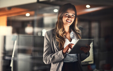 She thrives with hard work. Cropped shot of a young attractive businesswoman using a tablet while...