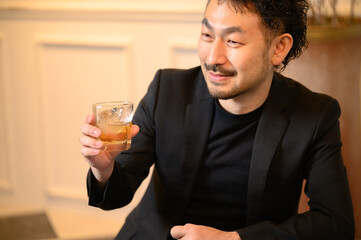 ウィスキーをバーで飲む男性