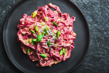 Red pasta with pistachio food on plate.