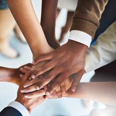 Teams dont work without teamwork. Cropped shot of a group of businesspeople piling their hands on...