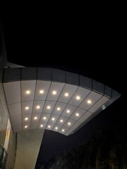 Blinking light in window of the multi-storey building of glass and steel lighting and people within timelapse close up view