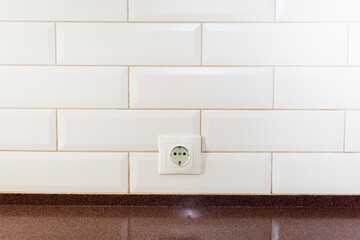 EU socket on the wall of tiled tiles in the kitchen