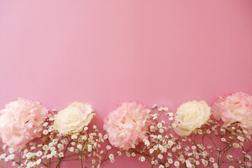 Fototapeta na wymiar feminine wedding desktop with baby's breath Gypsophila flowers and pink beautiful flowers on pink background. Empty space. Floral frame, web banner. Top view. Picture for blog or social media