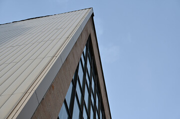 Fototapeta na wymiar Geometric composition of glass and concrete against a blue cloudless sky.