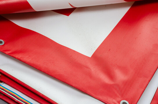 A red and white billboard. PVC fabric folded. Banner with eyelets.