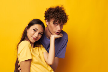 portrait of a man and a woman in colorful t-shirts posing friendship fun yellow background unaltered