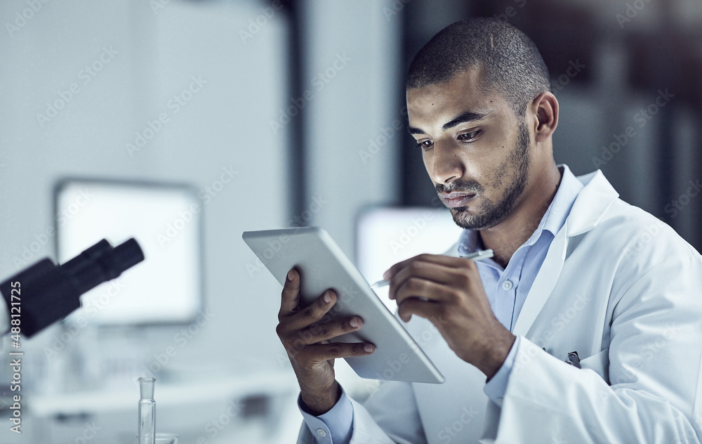 Poster taking advantage of electronical information. shot of a scientist recording his findings on a digita