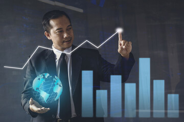 Businessman is pointing and globe is hovering over hand. Business growth concept, futuristic, and the future