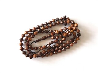 99 Islamic prayer beads on a white background for ramadan, eid adha, eid fitr, flyer islamic and etc . close up of wood tasbih