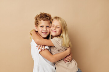 boy and girl in t-shirts hugs beige background friendship