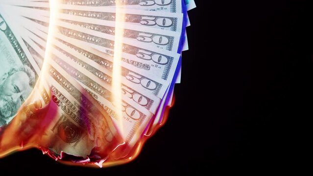 Burning of American 50 dollar banknotes on black background. Flame of fire from a bundle of cash. Financial crisis and depressed economy. Paper money loss concept.