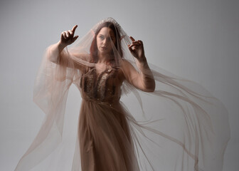  Full length portrait of pretty female model with red hair wearing glamorous fantasy tulle gown,...