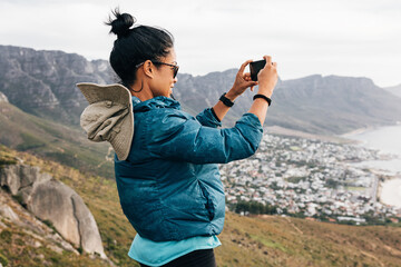 Woman tourist making photographs on mobile phone while hiking - obrazy, fototapety, plakaty