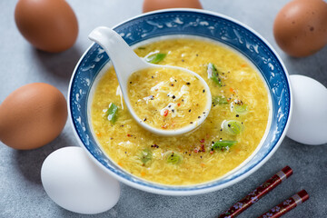 Bowl of danhuatang or chinese soup of wispy beaten eggs in chicken broth, middle closeup, horizontal shot
