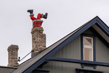 Figur eines Weihnachtsmanns steckt kopfüber in einem Kamin eines Wohnhauses in Reykjavik...