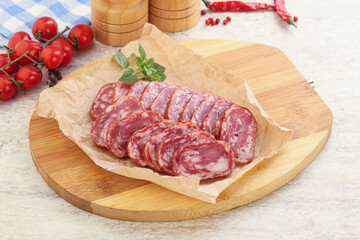 Sliced salami sausages over board