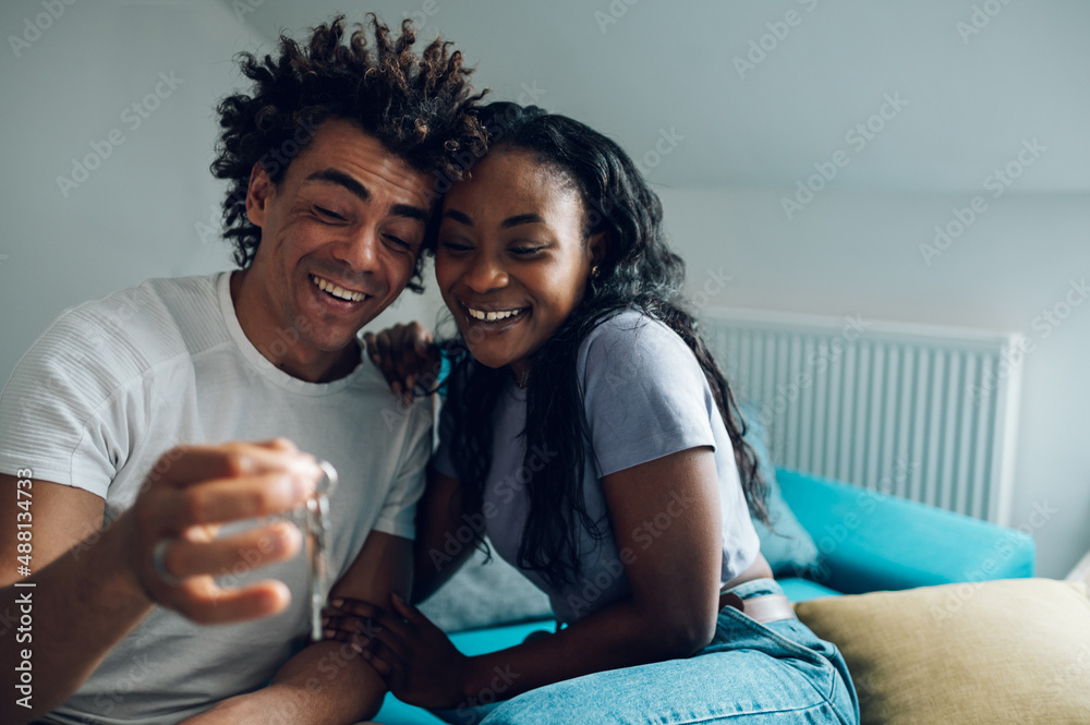 Wall mural african american couple holding home keys in their new apartment