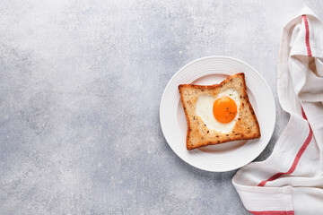 Breakfast on Valentines Day. Heart shaped egg with toast and microgreens on light grey background, breakfast table top. Valentines day breakfast. Top view. Mock up.