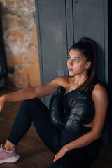 Obraz na płótnie Canvas Sporty woman in sportswear posing on camera with boxing gloves.