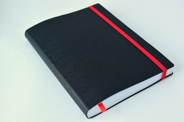 Black daily with white pages and a red bookmark. Close-up.