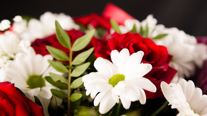 Closeup bouquet of red roses with with daisies.